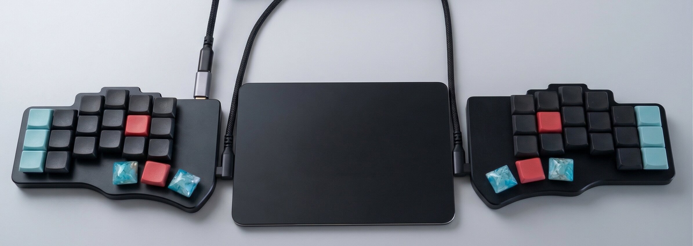 Split ergonomic keyboard with touchpad centered between halves